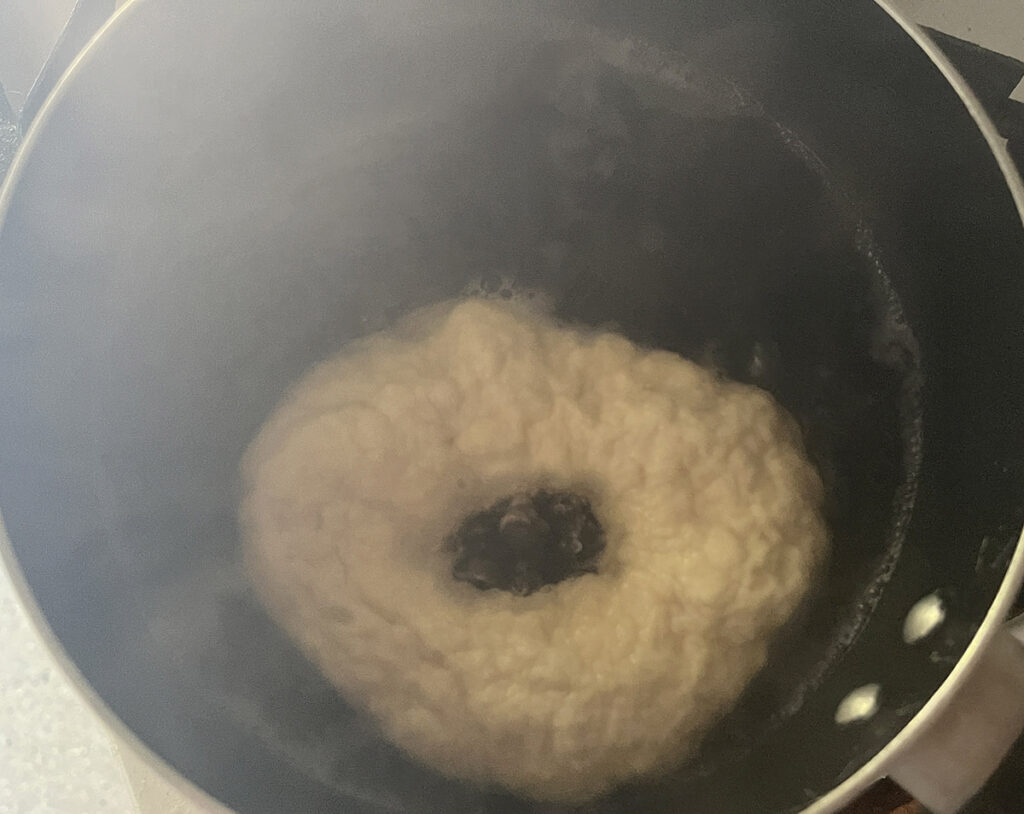 The raw dough of the bagel needs to be 'sealed' in boiling water before baking