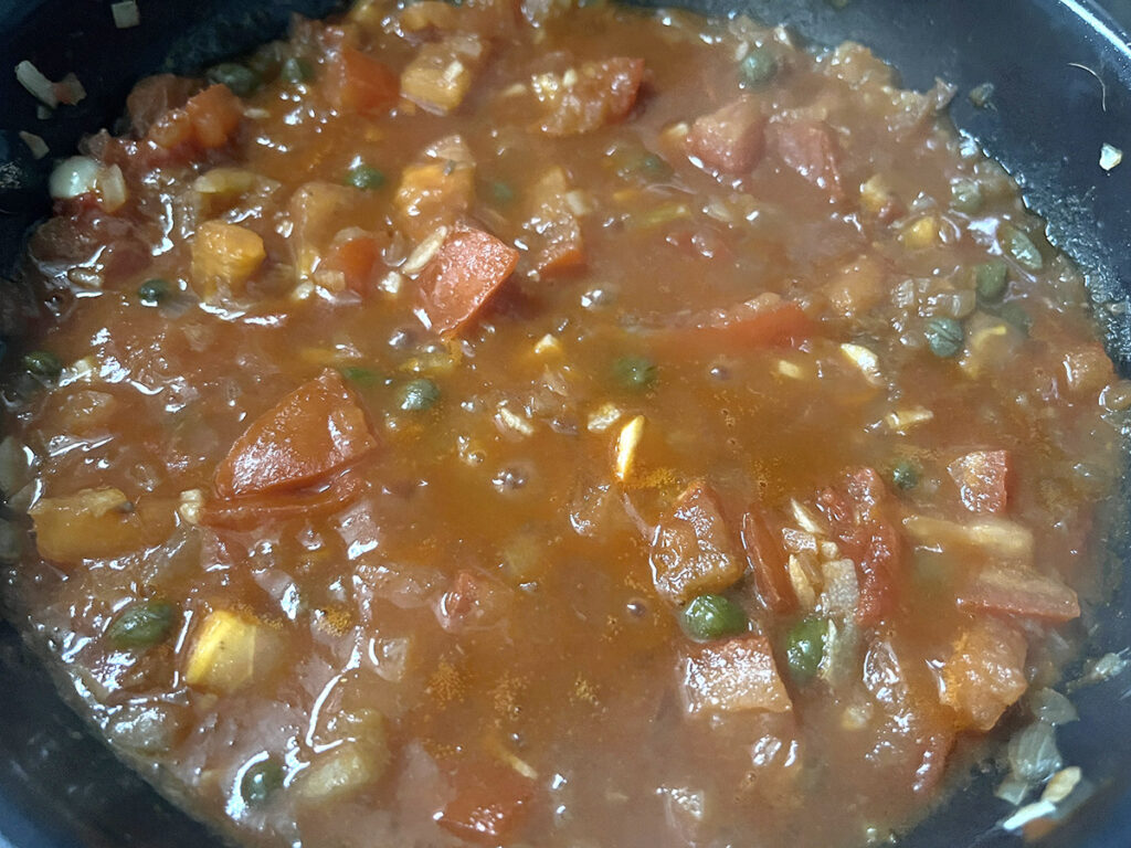 Simmer the pasta puttanesca sauce while the pasta cooks
