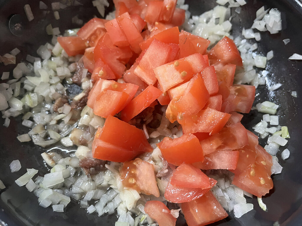 Fresh chopped tomatoes are added into the puttanesca sauce