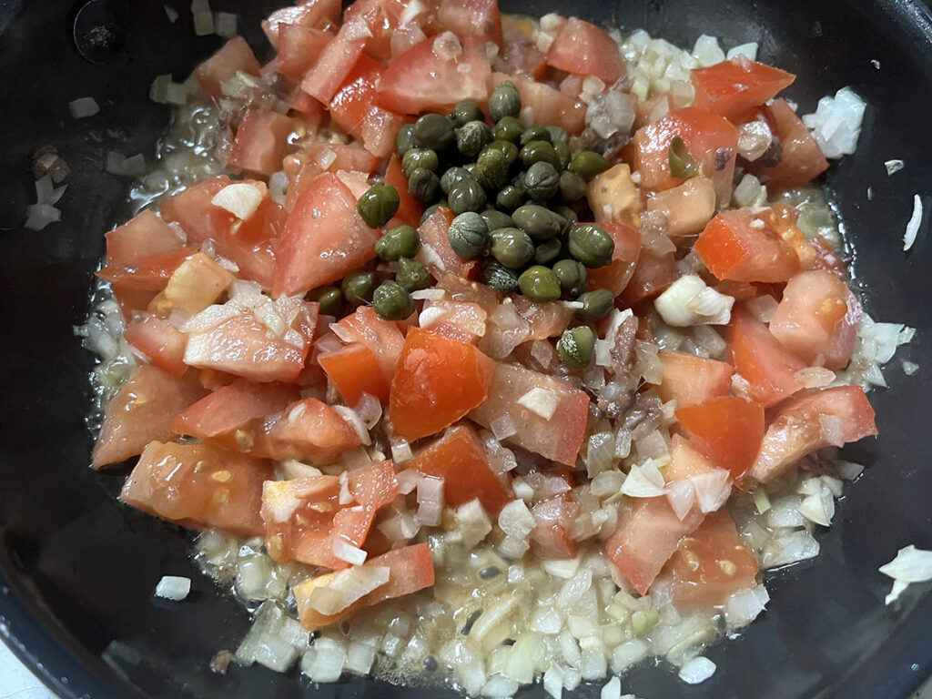 The capers are next to be added into the puttanesca sauce