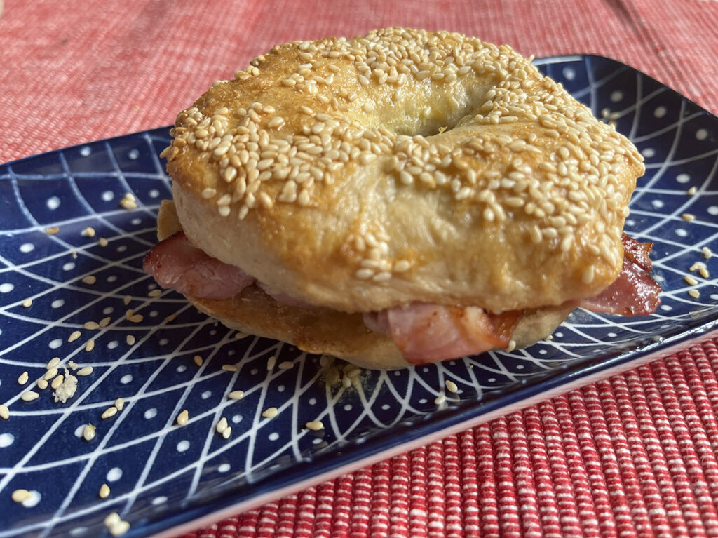 Toasted no-knead bagel with butter and crispy bacon